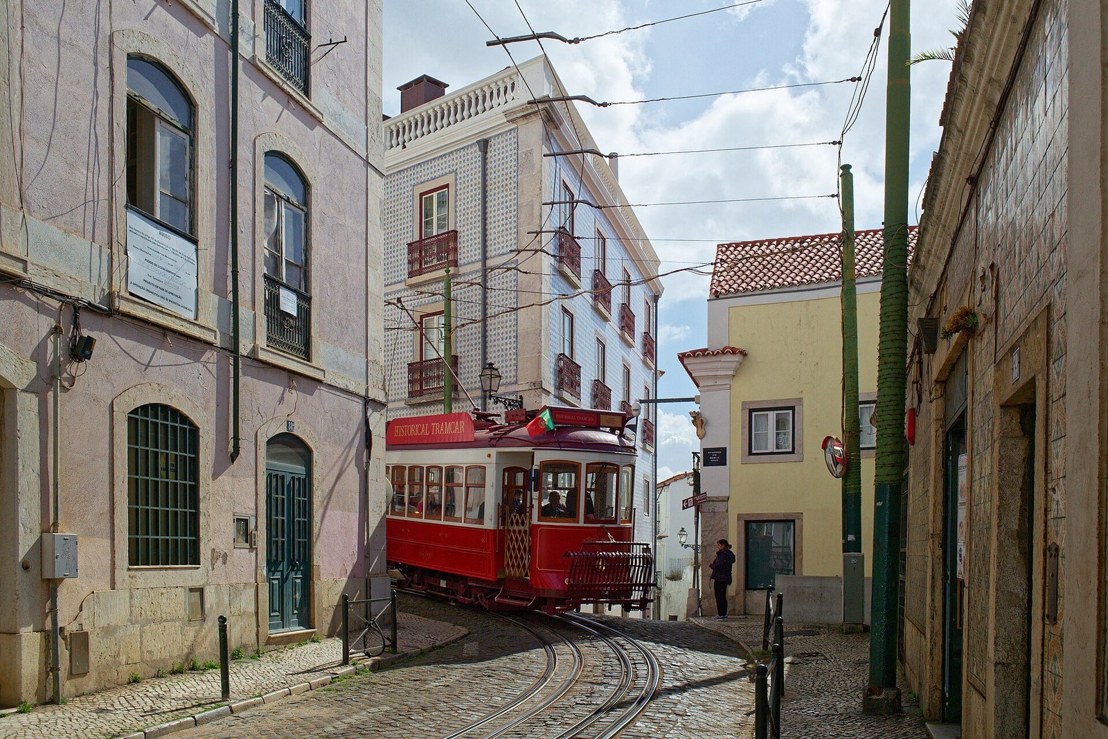 A red tram in a narrow street of Alfama, Lisbon