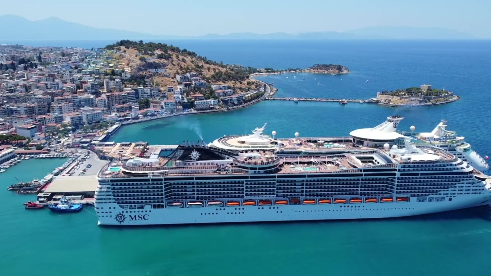 Kikötőben álló óceánjáró egy napfényes mediterrán városnál